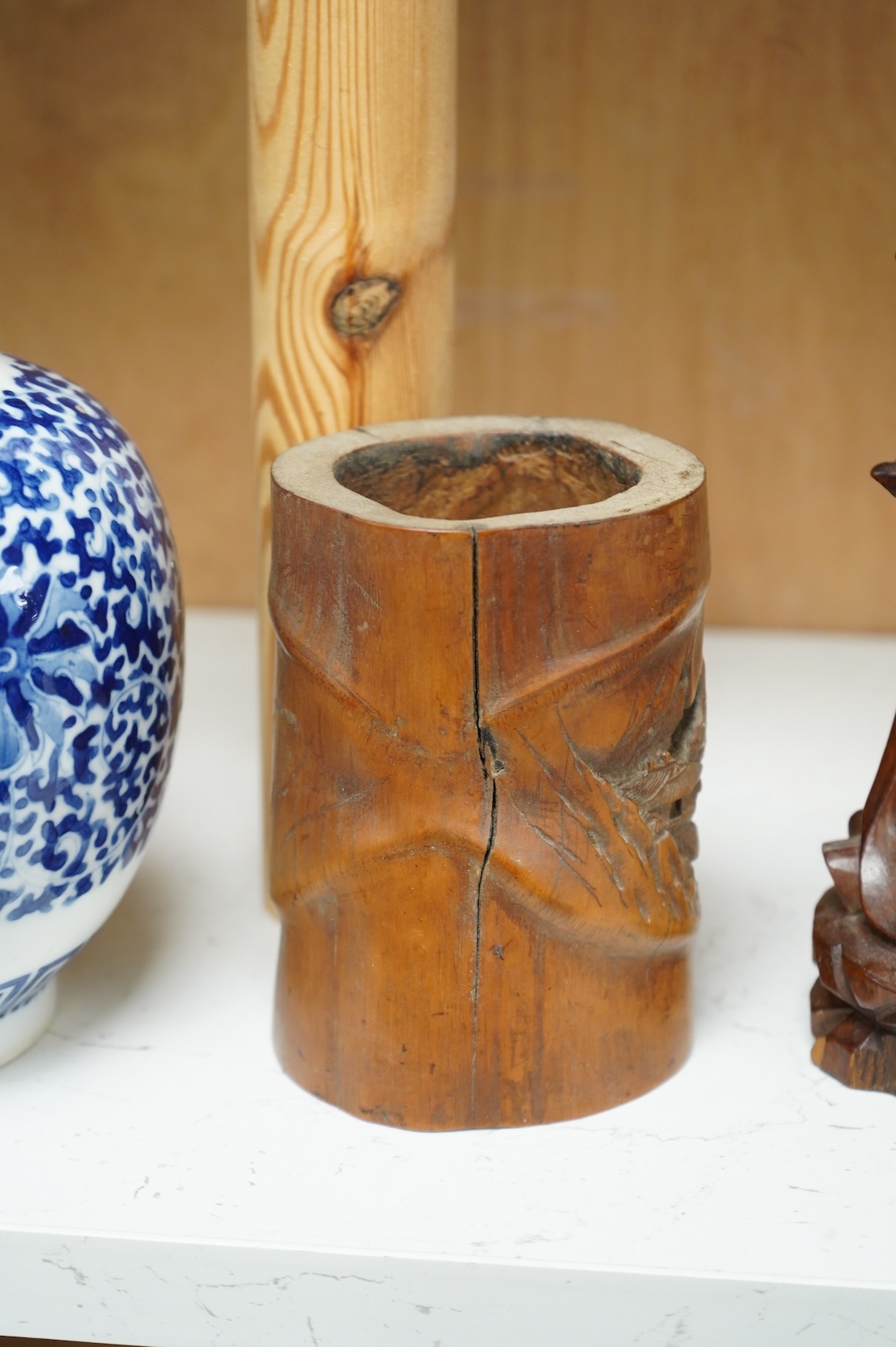 A bronzed Chinese figure of Qianlong, a carved bamboo brush pot and a hardwood figure, largest 20cm high